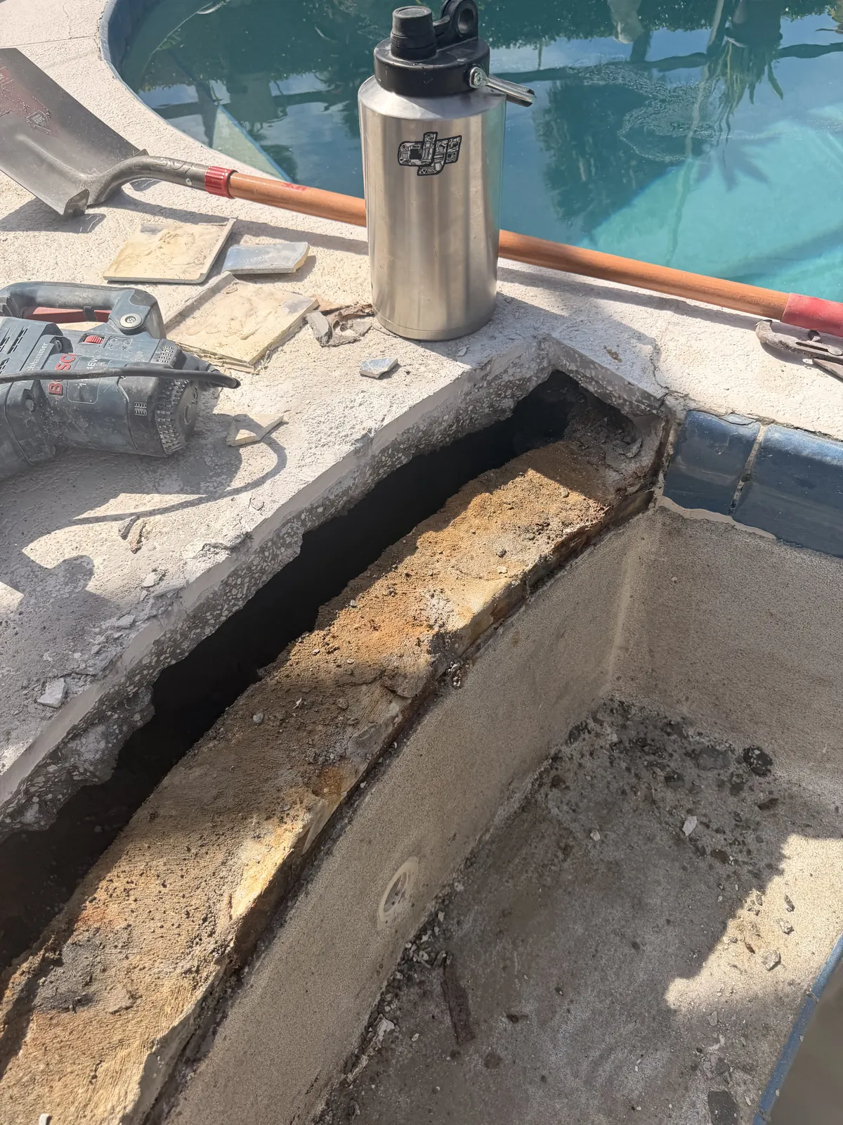 Decking cut back to expose the failed cold joint between the deck slab and spa shell — Deltona, FL