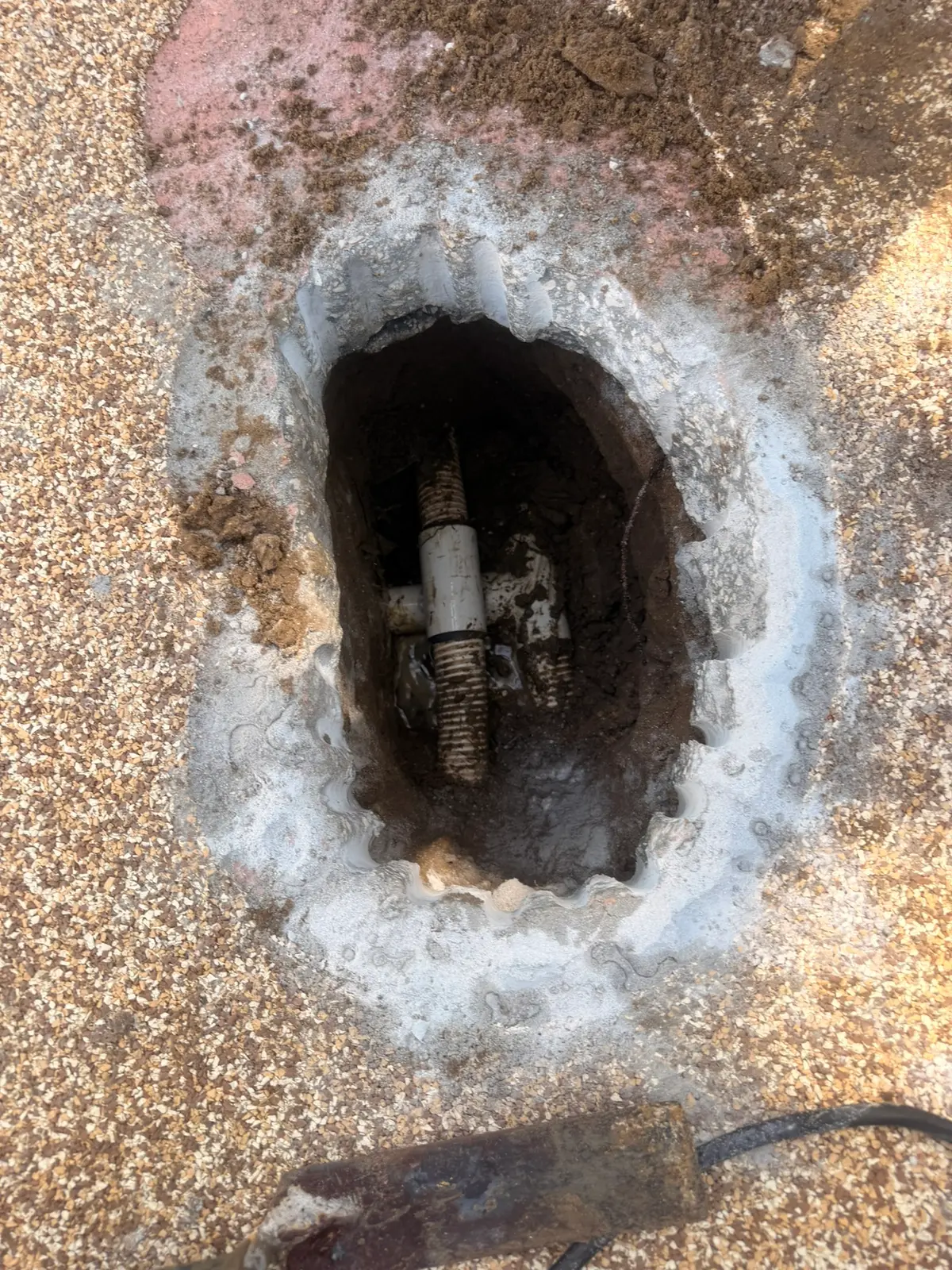 Concrete pool deck saw-cut open directly over a pinpointed spa therapy jet leak — New Smyrna Beach, FL