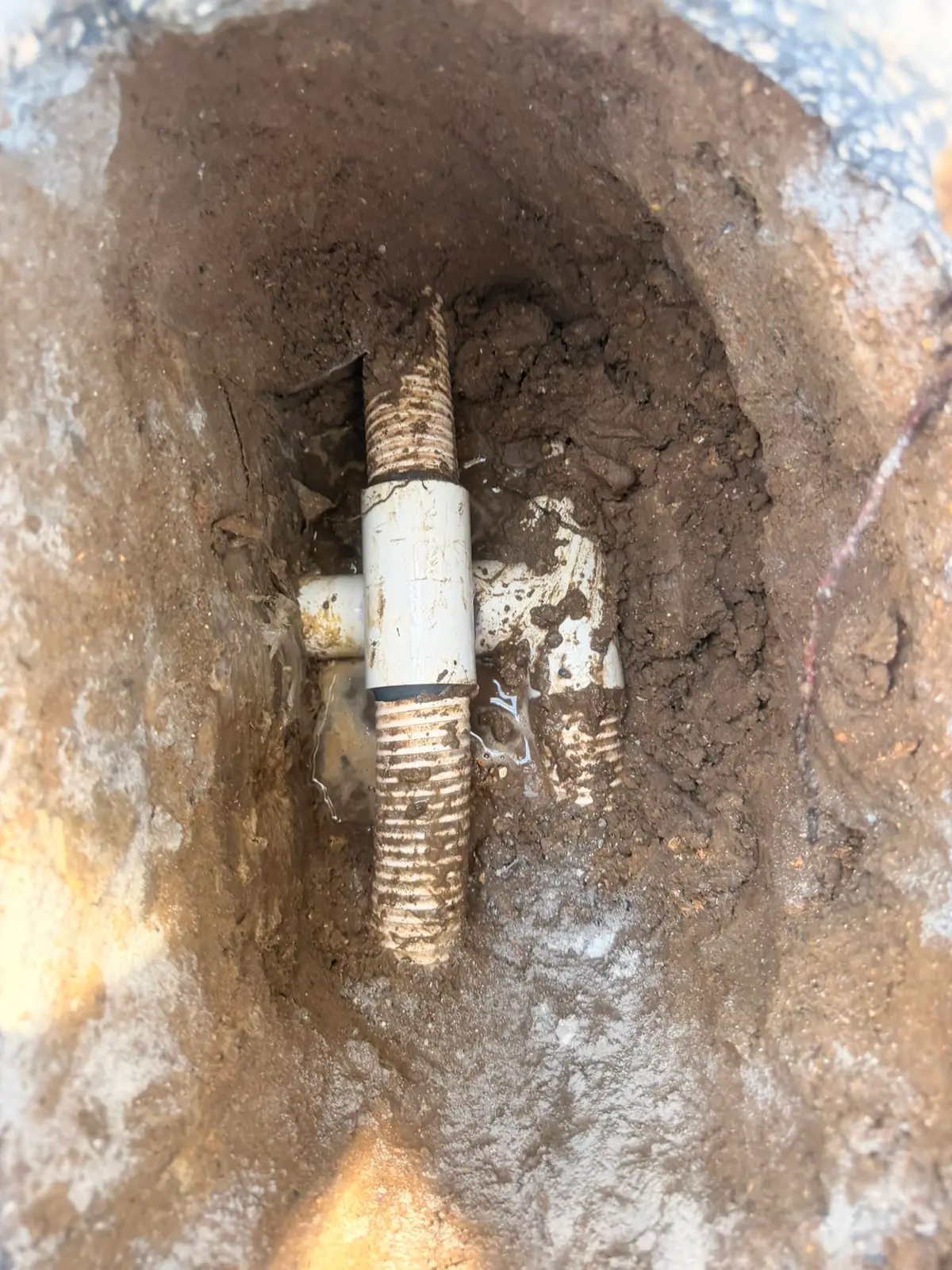Excavation exposing the spa therapy jet's venturi fitting below the deck — New Smyrna Beach, FL